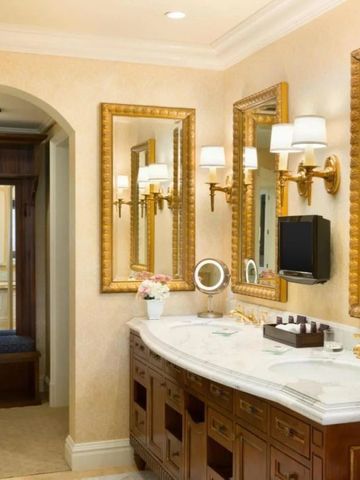 Geschmackvoll eingerichtetes Badezimmer mit Marmorwaschtisch und goldenen Akzenten