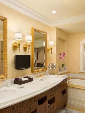 Elegant gestaltetes Badezimmer mit Doppelwaschtischen aus Marmor und Badewanne