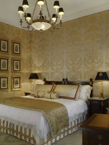 Hochwertig eingerichtetes Zimmer mit goldener Tapete und stilvoller Beleuchtung