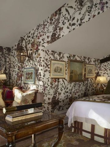 Zimmer mit floralen Tapeten und klassischem Mobiliar