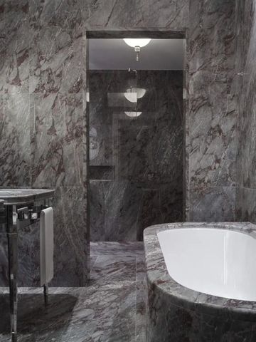 Luxuriöses Badezimmer mit Marmordetails und freistehender Badewanne.