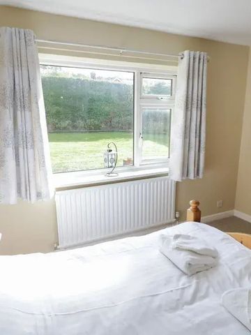 Schlafzimmer mit Doppelbett und Blick auf grünen Garten