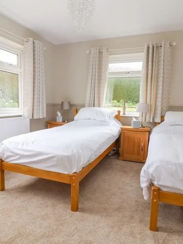 Zweibettzimmer mit klassischen Holzmöbeln und Gartenblick