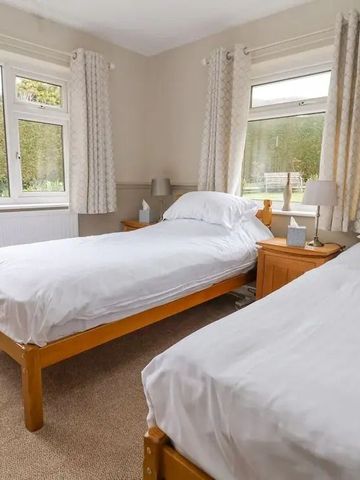 Helles Schlafzimmer mit zwei Einzelbetten und großen Fenstern