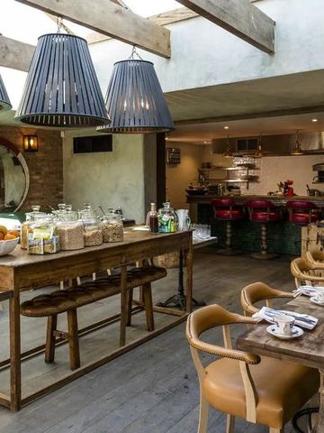 Gemütlicher Frühstücksraum mit rustikalen Holzmöbeln und großen Deckenlampen.