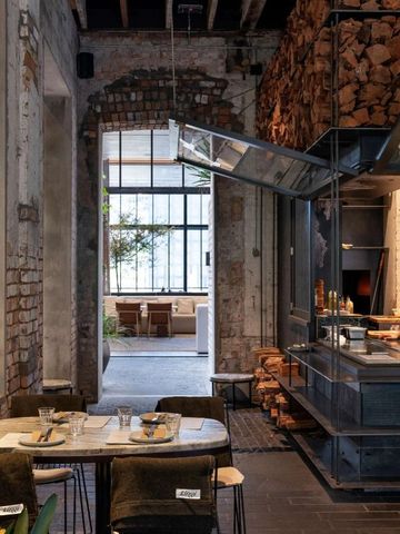 Modernes Restaurantinterieur mit Holzofen und stilvollen Sitzgelegenheiten