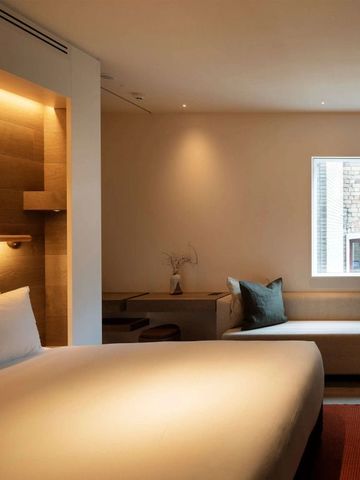 Gemütliches Hotelzimmer mit weichem Bett und Sitzbereich am Fenster