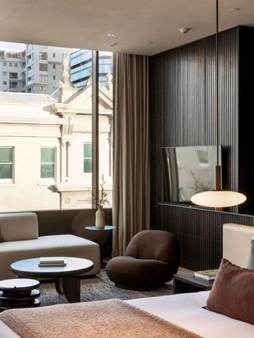 Stilvolles Hotelzimmer mit großen Fenstern und Blick auf die Stadt