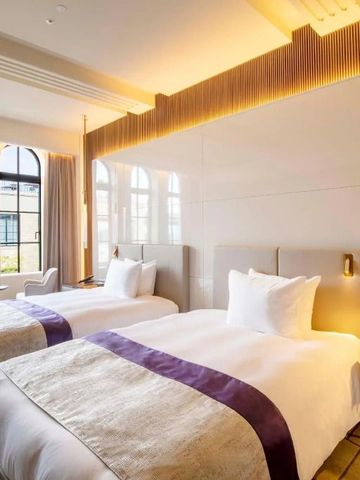 Zimmer mit zwei Einzelbetten, modernen Designelementen und viel Tageslicht