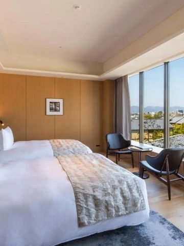 Geräumiges Zimmer mit Panoramablick auf die Stadt und einladenden Betten