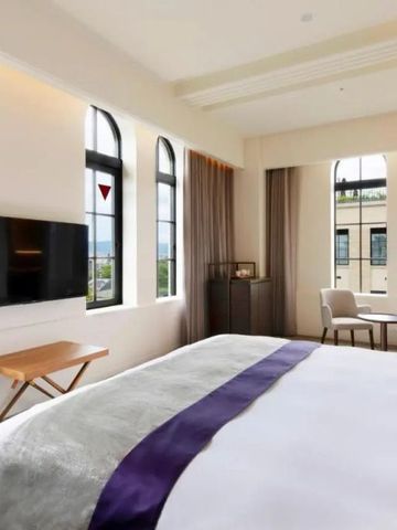 Helles Zimmer mit Panoramablick und edlem Bett vor großen Fenstern