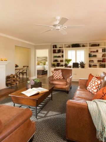 Gemütliches Wohnzimmer mit Kamin, Ledersofas und Bücherregalen