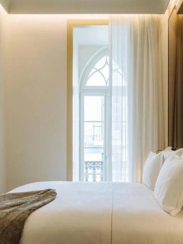 Modern eingerichtetes Hotelzimmer mit weichem Bett und großem Fenster