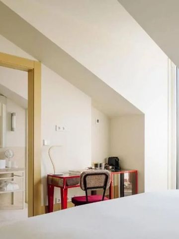 Helles Dachzimmer mit Schreibtisch und modernem Badezimmer