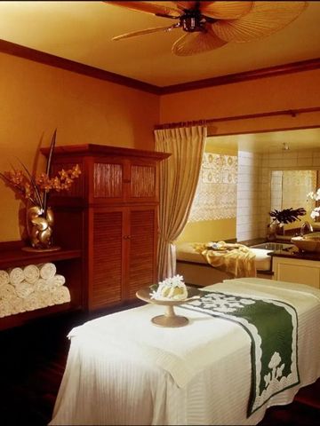 Einladender Spa-Raum mit Massagebett und entspannendem Licht.