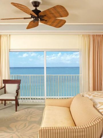 Luxuriöses Schlafzimmer mit Panoramablick auf das Meer vom Balkon.