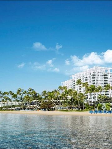 Strand mit Palmen und Blick auf das Hotel in der Ferne