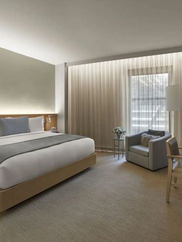 Helles Hotelzimmer mit großen Fenstern und eleganter Einrichtung