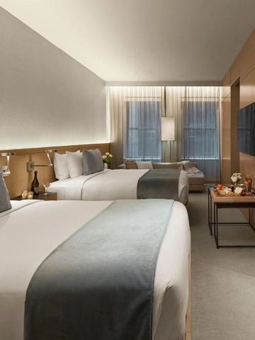 Geräumiges Hotelzimmer mit zwei großen Betten und eleganter Einrichtung