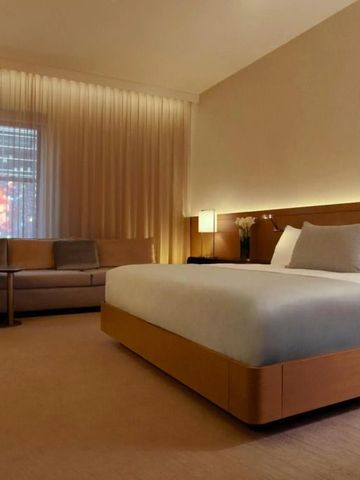 Modernes Hotelzimmer mit Kingsize-Bett und dezenter Beleuchtung