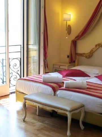 Charmantes Doppelzimmer mit Balkon und eleganten Verzierungen.