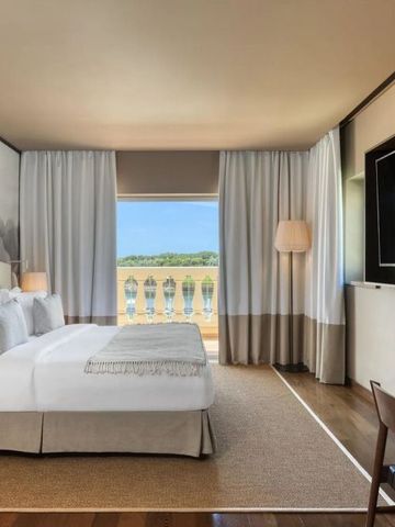 Helles Hotelzimmer mit großem Fenster und Aussicht.