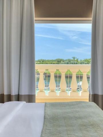 Balkonaussicht auf grünen Garten und blauen Himmel.