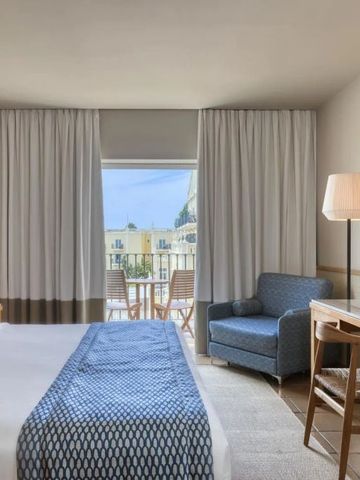 Komfortables Zimmer mit Balkon und Sitzbereich.