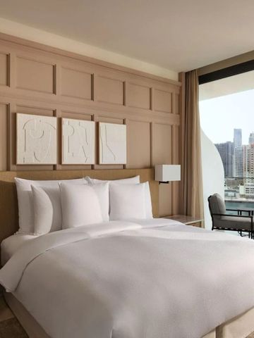 Komfortables Hotelzimmer mit großem Bett und städtischem Panoramablick