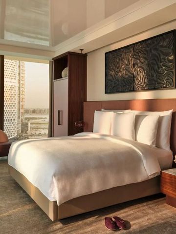 Geräumiges Zimmer mit Doppelbett, moderner Kunst und Blick auf die Skyline