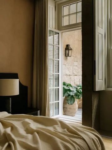 Gemütliches Schlafzimmer mit offenem Fenster und Blick auf eine Pflanze.