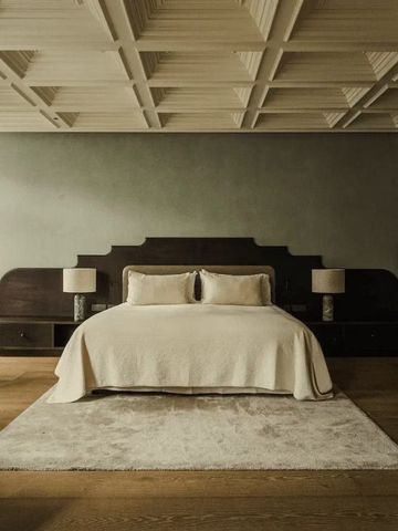 Großes Bett mit weich bezogenen Kissen und eleganter Wandgestaltung.