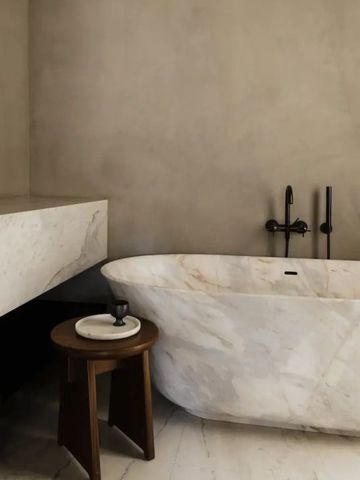 Modernes Badezimmer mit Marmorbadewanne und Tisch