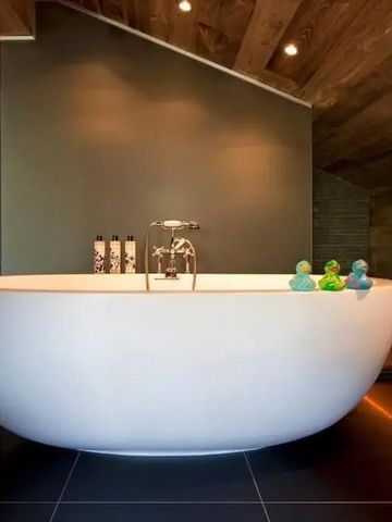 Moderne freistehende Badewanne in stilvollem Badezimmer mit Holzakzenten