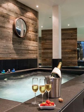 Luxuriöser Innen-Whirlpool mit Champagner und Früchten, umgeben von edlem Holzdekor.
