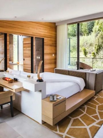 Modernes Hotelzimmer mit großem Fenster und Blick auf die Natur