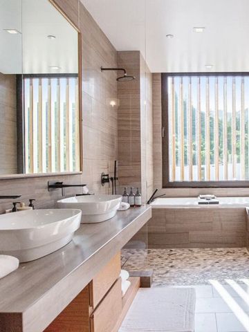 Luxuriöses Badezimmer mit zwei Waschbecken und großem Fenster