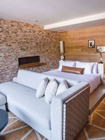 Komfortables Schlafzimmer mit Ziegelwand und modernem Sofa