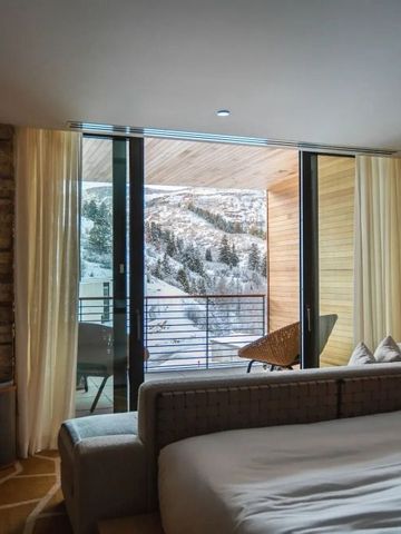 Zimmer mit Balkon und verschneitem Bergblick