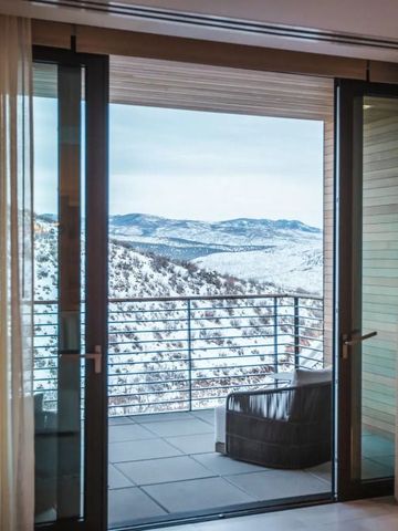 Schneebedecktes Bergpanorama von einem privaten Balkon mit Sitzgelegenheit