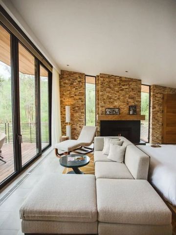 Modernes Wohnzimmer mit Kamin und großen Fenstern im alpinen Stil