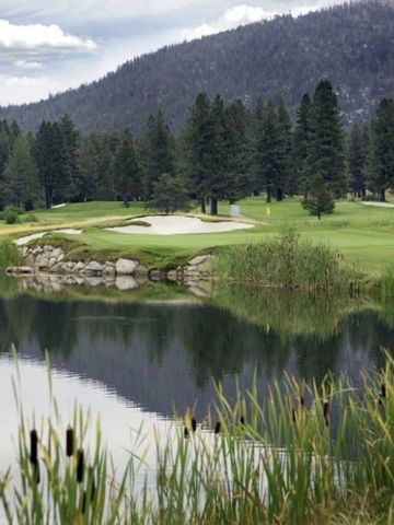 Ruhiger See mit reflektierender Wasseroberfläche und Waldhintergrund