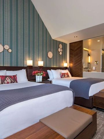 Modernes Zimmer mit zwei Doppelbetten und stilvoller Wanddekoration