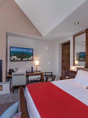 Elegantes Hotelzimmer mit Kamin und moderner Einrichtung in warmen Farben