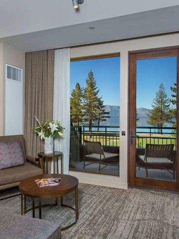 Elegantes Hotelzimmer mit Sitzbereich und Blick auf den See.