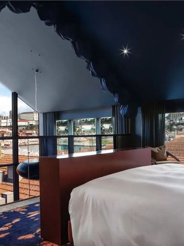 Elegantes Hotelzimmer mit Dachfenster und Blick auf die Stadt.