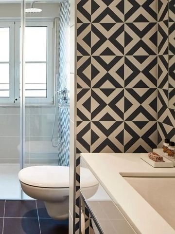 Modernes Badezimmer mit geometrischen Fliesen und großer Dusche
