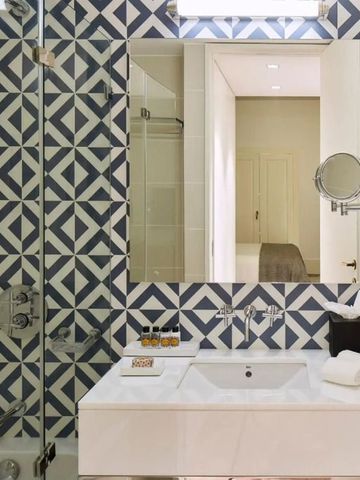 Badezimmer mit modernen Fliesen und großen Spiegeln für ein luxuriöses Ambiente