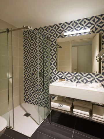 Modernes Badezimmer mit eleganten Kacheln und geräumiger Dusche