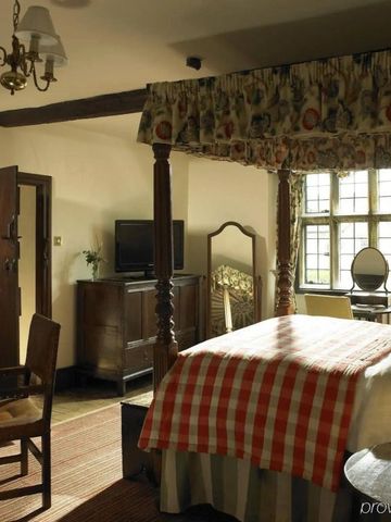 Gemütliches Hotelzimmer mit Himmelbett und Holzinterieur im Lygon Arms.